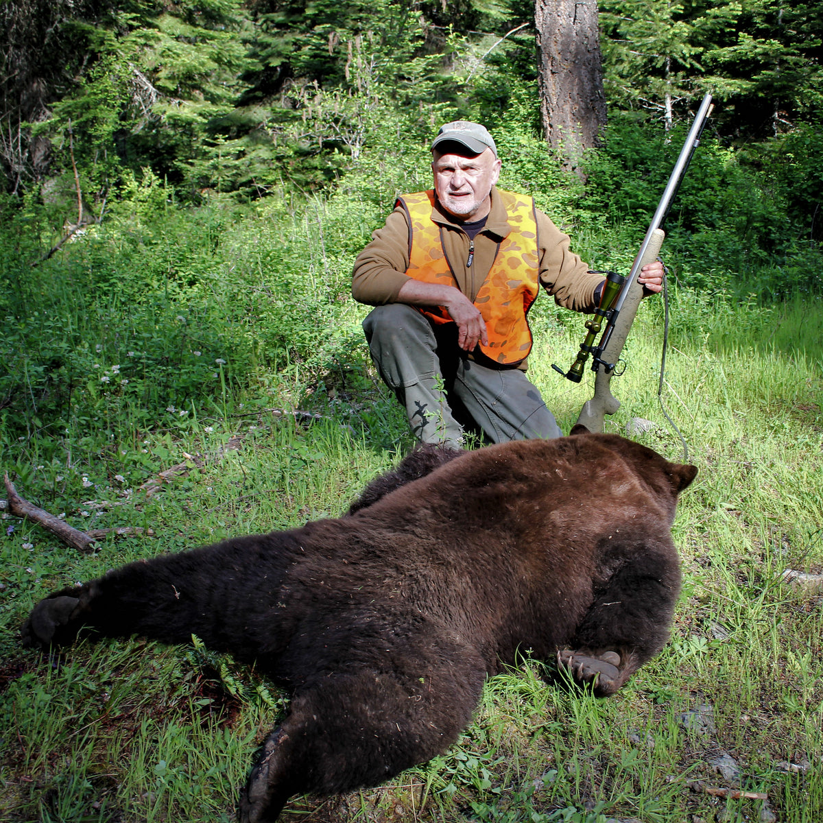 A hunter poses with a bear, taken down by the M40 scope on a bolt action